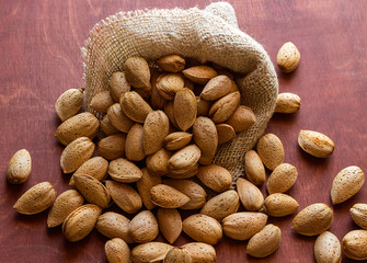 Almonds in the shell on a wooden table.