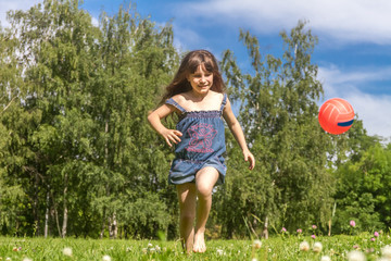 outdoor portrait of young happy girl playing will ball on natura