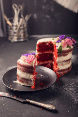 Red velvet cake with flowers on dark wooden background