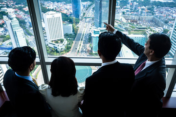 Group of Asian businesspeople looking at city skyline
