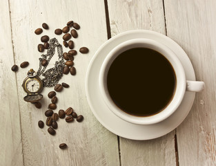 Black coffee, vintage style chain watch and coffee beans