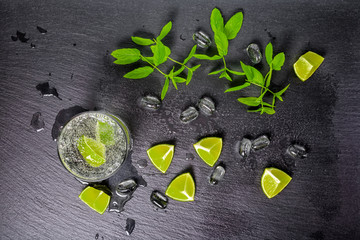 mojito cocktail with splash, ice, green mint, cuted limes and dr