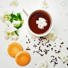 Tea cup with dried and fresh Jasmine flowers and cookies