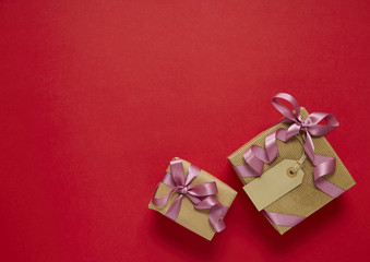Birthday presents wrapped in brown paper with bows on a red background arranged to form a border