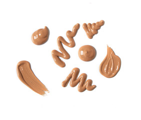 Smears of dark colored foundation make up isolated on a white background