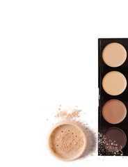 A concealer make up palette and mineral powder foundation isolated on a white background forming a page border