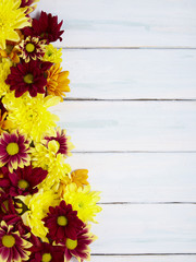 A page border made up of orange, red and yellow flowers on a white painted reclaimed wood background