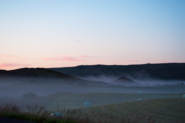 Fototapeta na wymiar Islanda: il paesaggio islandese al tramonto, con la nebbia e i covoni di fieno il 20 agosto 2012. Il paesaggio islandese è considerato in tutto il mondo unico e diverso da qualsiasi altro sul pianeta