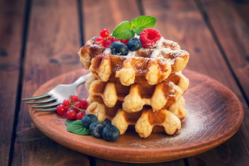 Belgian waffles with raspberries,currant,blueberries and sprinkled with sugar