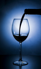 Liquor being poured into a glass. Silhouette