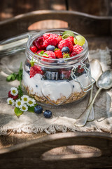 Granola and yogurt decorated with flowers in garden