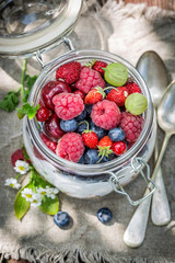 Granola and yogurt decorated with flowers in sunny day