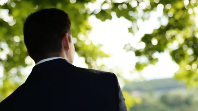 man in the suit admires the nature