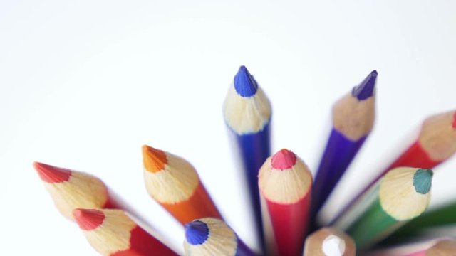 Color pencils turning on a white background. Close up. 
