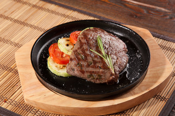 Steak flambe on black pan