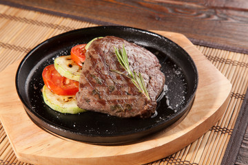 Steak flambe on black pan