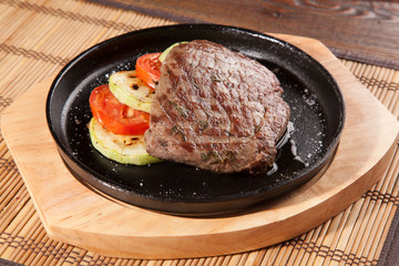 Steak flambe on black pan