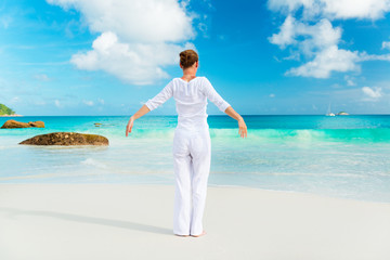 Woman practices yoga on the tropical beach