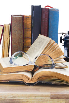 Old books, glasses over white background - writting and publishing concept