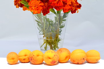 Букет бархатцев и абрикосы на переднем плане 