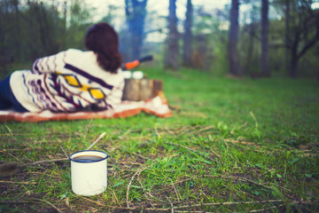 Coffee mug with resting the girl in the background.