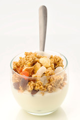 glass of yogurt with  cereal fruit and golden spoon
