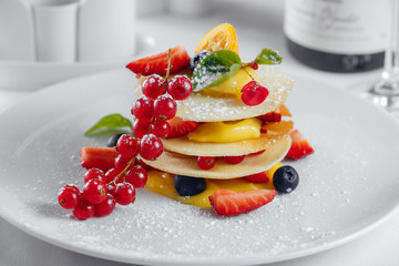 Red currant, lemon, strawberry and olives on a white plate