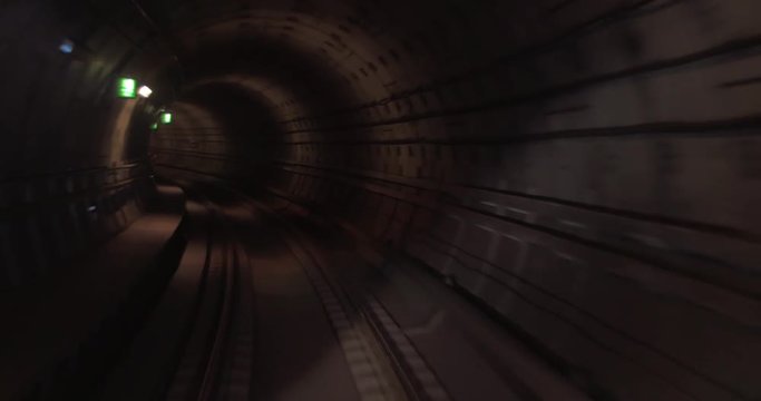 Train moving forward in the dark and gloomy underground tunnel. View from the cabin to railtrack. Paris, France