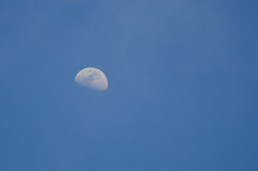 Part of the moon on a background of blue sky