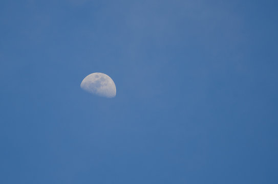 Part of the moon on a background of blue sky