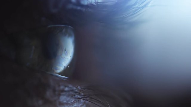 Human eyes blinking in the darkness with backlight