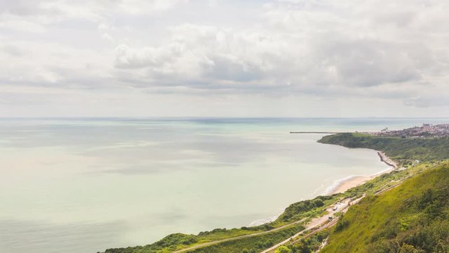 Time-lapse view of clouds over English Channel from cliffs of Dover. The city on background is Folkestone, there are also rail tracks on the bottom right. Travel and time concepts.