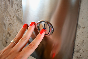 Female hand pressing elevator button