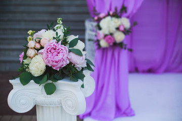 Beautiful wedding interior and table decor, flower decoration with flowers bouquet, with roses, tulips, peonies for outdoor wedding ceremony	