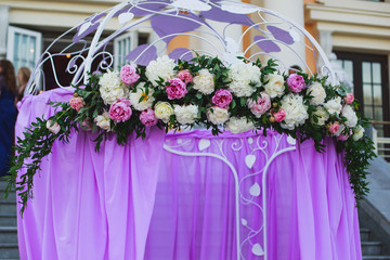 Beautiful wedding interior and table decor, flower decoration with flowers bouquet, with roses, tulips, peonies for outdoor wedding ceremony	