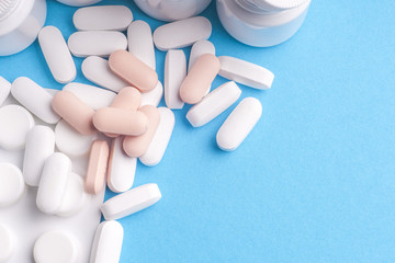 Many pills and tablets isolated on light blue background