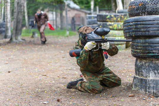 Young man in extreme process of paintball game