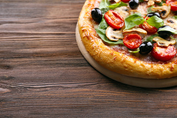 Delicious tasty pizza with ingredients on wooden table