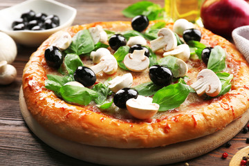 Delicious tasty pizza with ingredients on wooden table