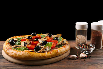 Delicious tasty pizza with ingredients on wooden table