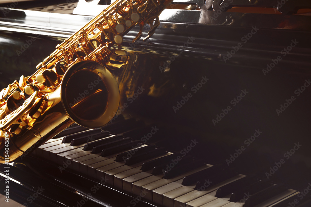 Wall mural saxophone lying on the piano, close up