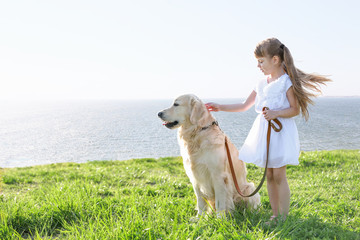 Little girl and big kind dog on the riverside