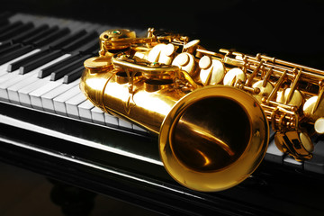 Saxophone lying on the piano, close up