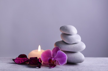 Fototapeta na wymiar White spa stones with candle on gray background