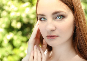 Portrait of beautiful girl on blurred nature background