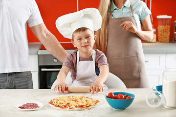 Happy family making pizza in kitchen