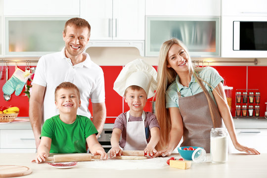 Happy family making pizza in kitchen