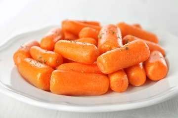 Small baby carrots on white plate