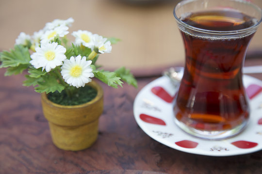 Black Tea with daisies in pots.a glass of turkish tea