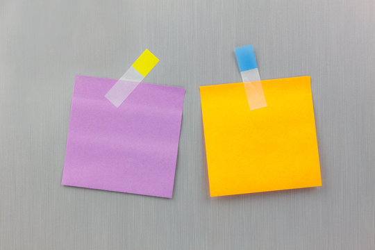Paper notes with sticky note on refrigerator background.